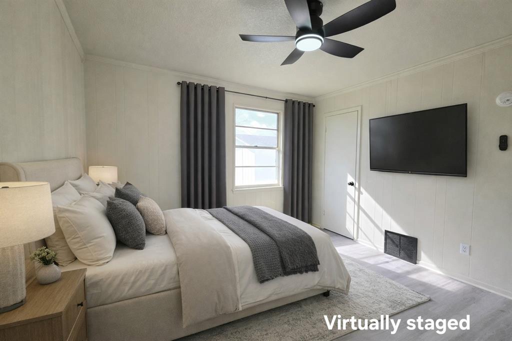 406 East Brazos Street Groesbeck, TX 76642 - Photo 13 of 29 a large bedroom with a bed and a flat screen tv