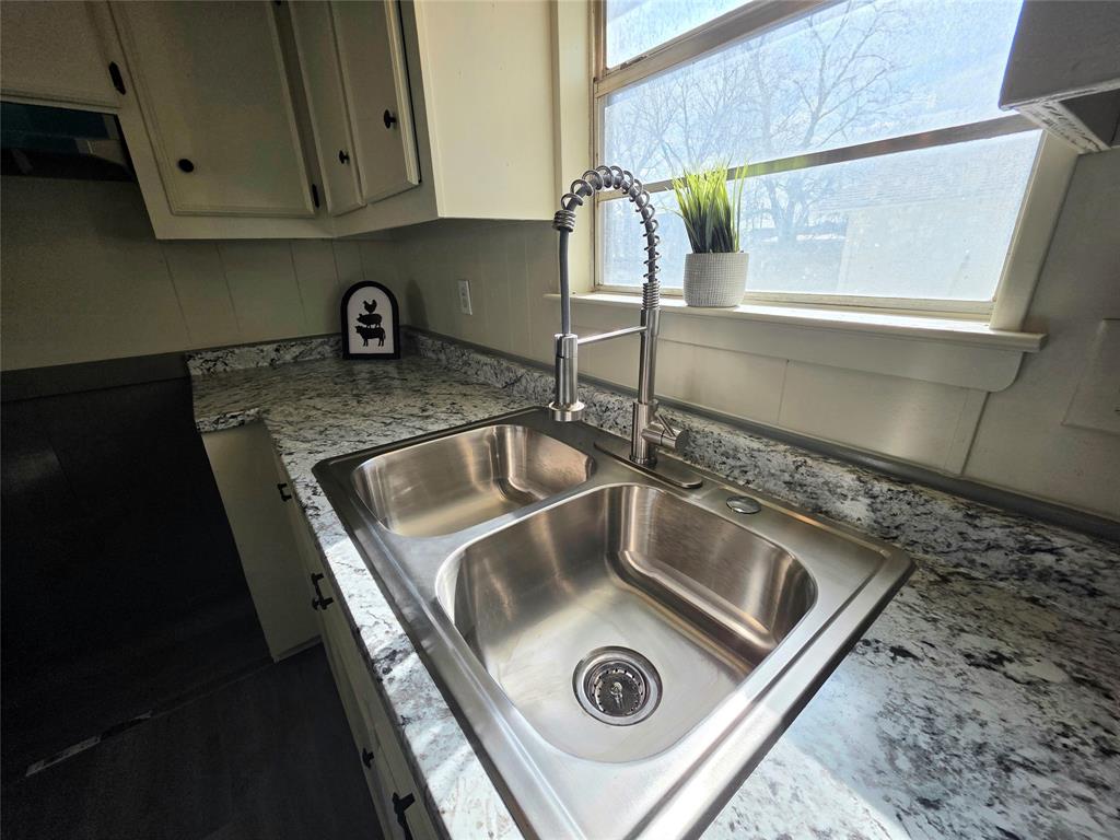 406 East Brazos Street Groesbeck, TX 76642 - Photo 20 of 29 a kitchen with a sink and a stove with wooden floor