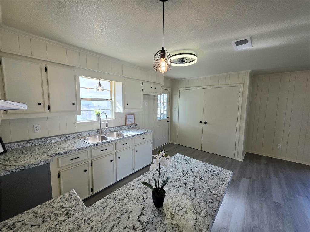 406 East Brazos Street Groesbeck, TX 76642 - Photo 21 of 29 a bathroom with a granite countertop sink a light fixture and a window