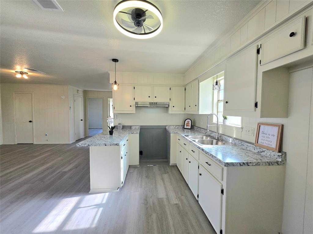 406 East Brazos Street Groesbeck, TX 76642 - Photo 3 of 29 a kitchen with cabinets a sink and a stove
