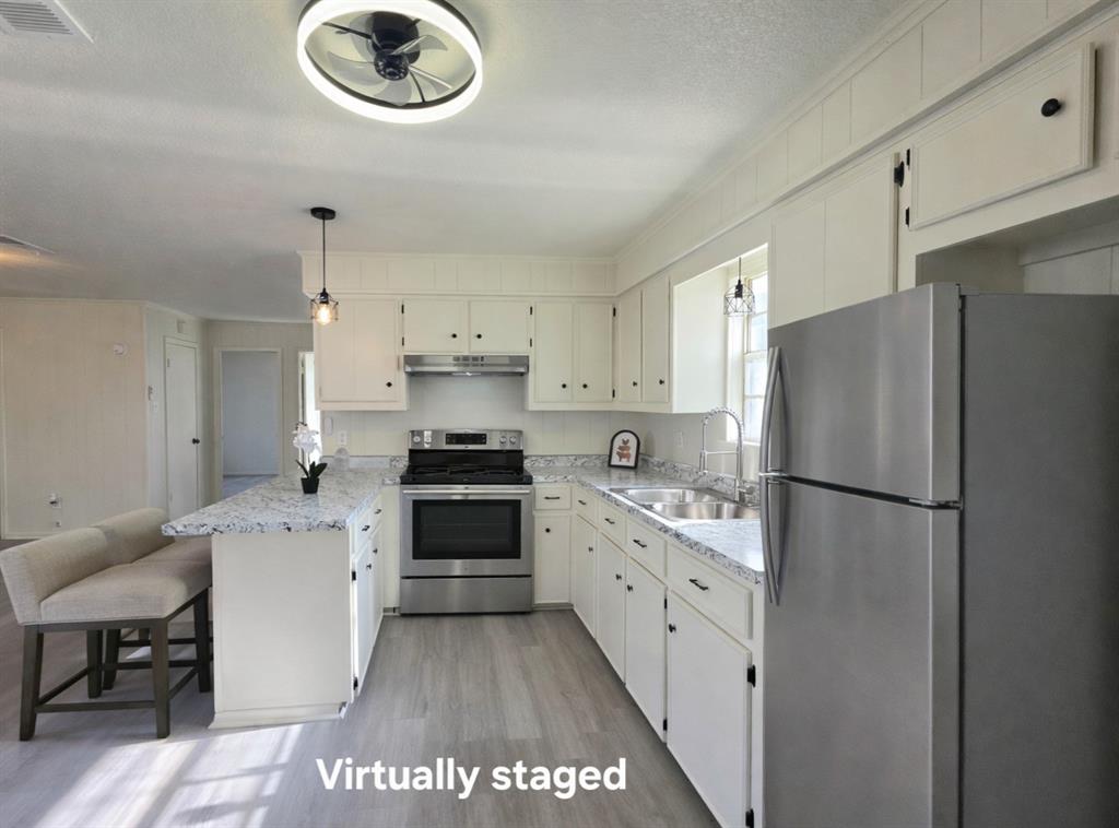 406 East Brazos Street Groesbeck, TX 76642 - Photo 4 of 29 a kitchen with stainless steel appliances a refrigerator sink and cabinets