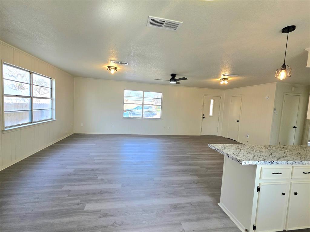 406 East Brazos Street Groesbeck, TX 76642 - Photo 5 of 29 an empty room with wooden floor and windows