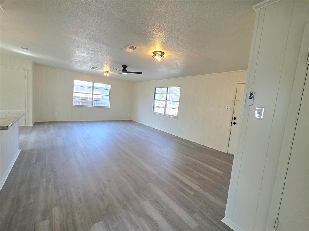 406 East Brazos Street Groesbeck, TX 76642 - Photo 7 of 29 an empty room with wooden floor and windows