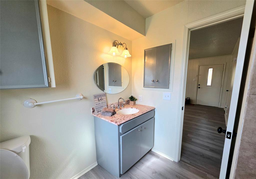 406 East Brazos Street Groesbeck, TX 76642 - Photo 9 of 29 a bathroom with a sink vanity granite and a mirror