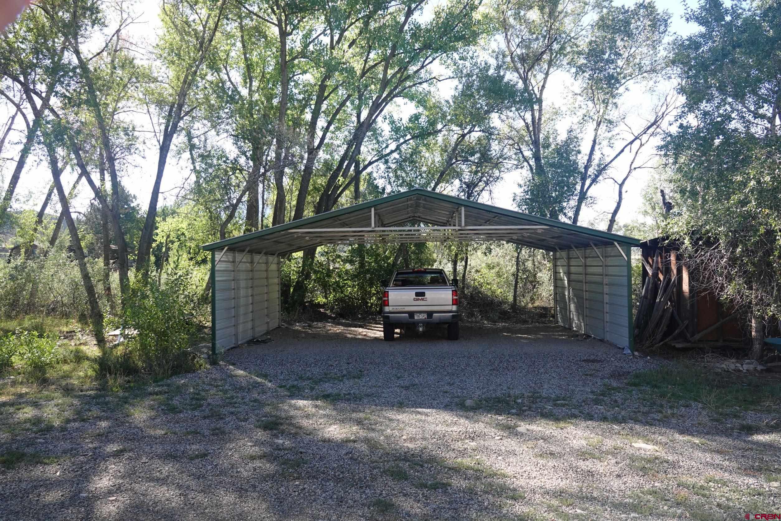 15835 Black Bridge Road Paonia, CO 81428 - Photo 16 of 35 a view of a small yard with a table and chair under an umbrella