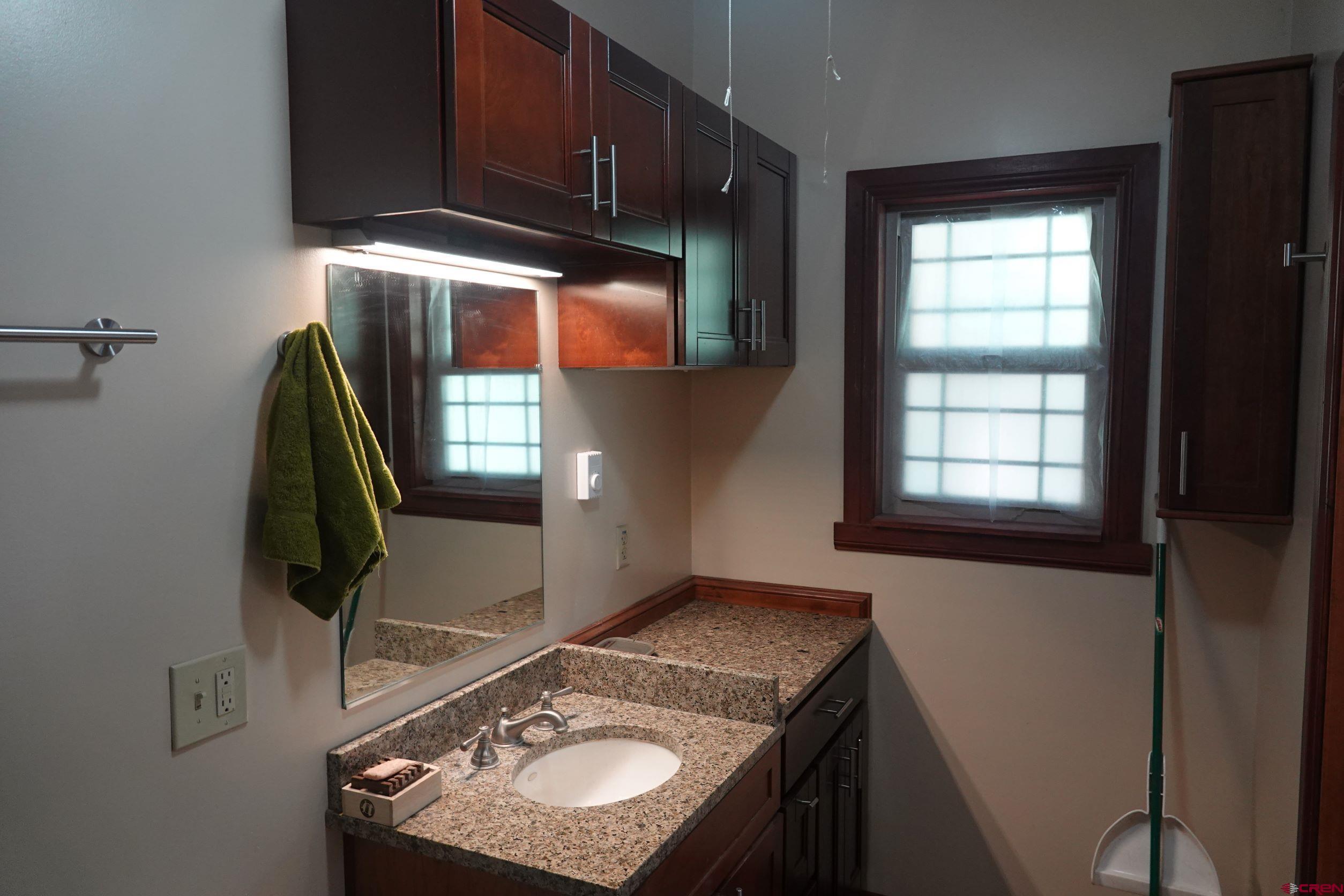 15835 Black Bridge Road Paonia, CO 81428 - Photo 31 of 35 a bathroom with a granite countertop sink and a mirror