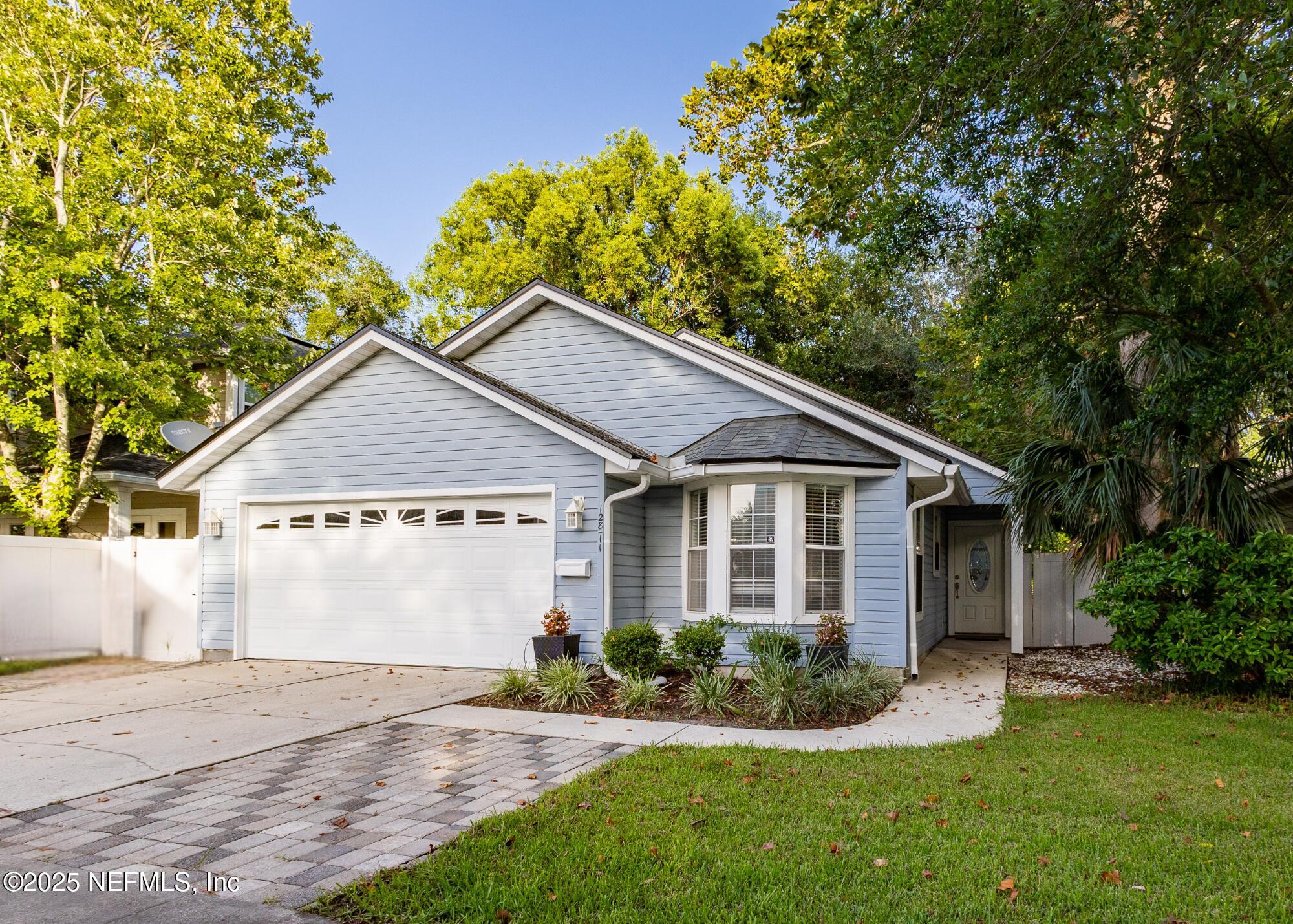 128 Seminole Road, Unit 11 Atlantic Beach, FL 32233 - Photo 1 of 26 a view of a yard in front of a house with plants and large tree