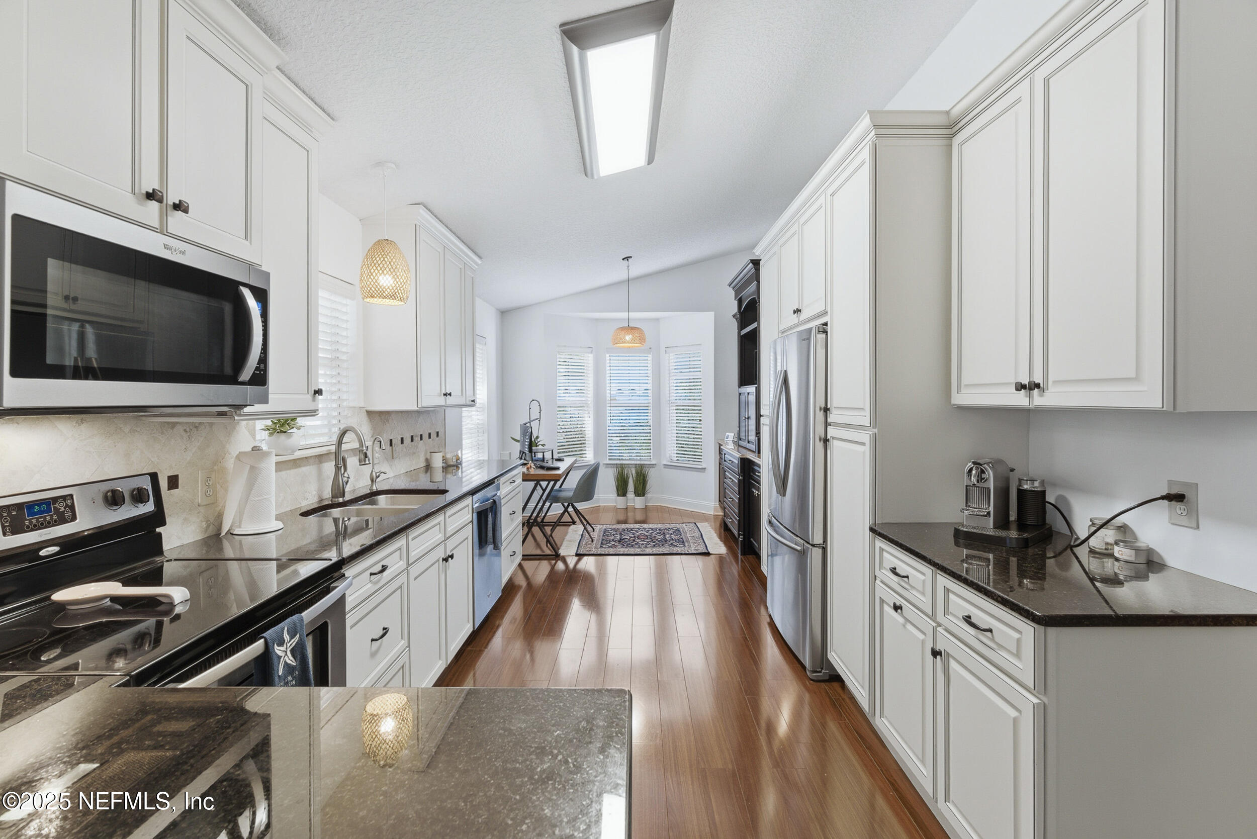 128 Seminole Road, Unit 11 Atlantic Beach, FL 32233 - Photo 6 of 26 a large kitchen with stainless steel appliances granite countertop a lot of counter space and wooden floors