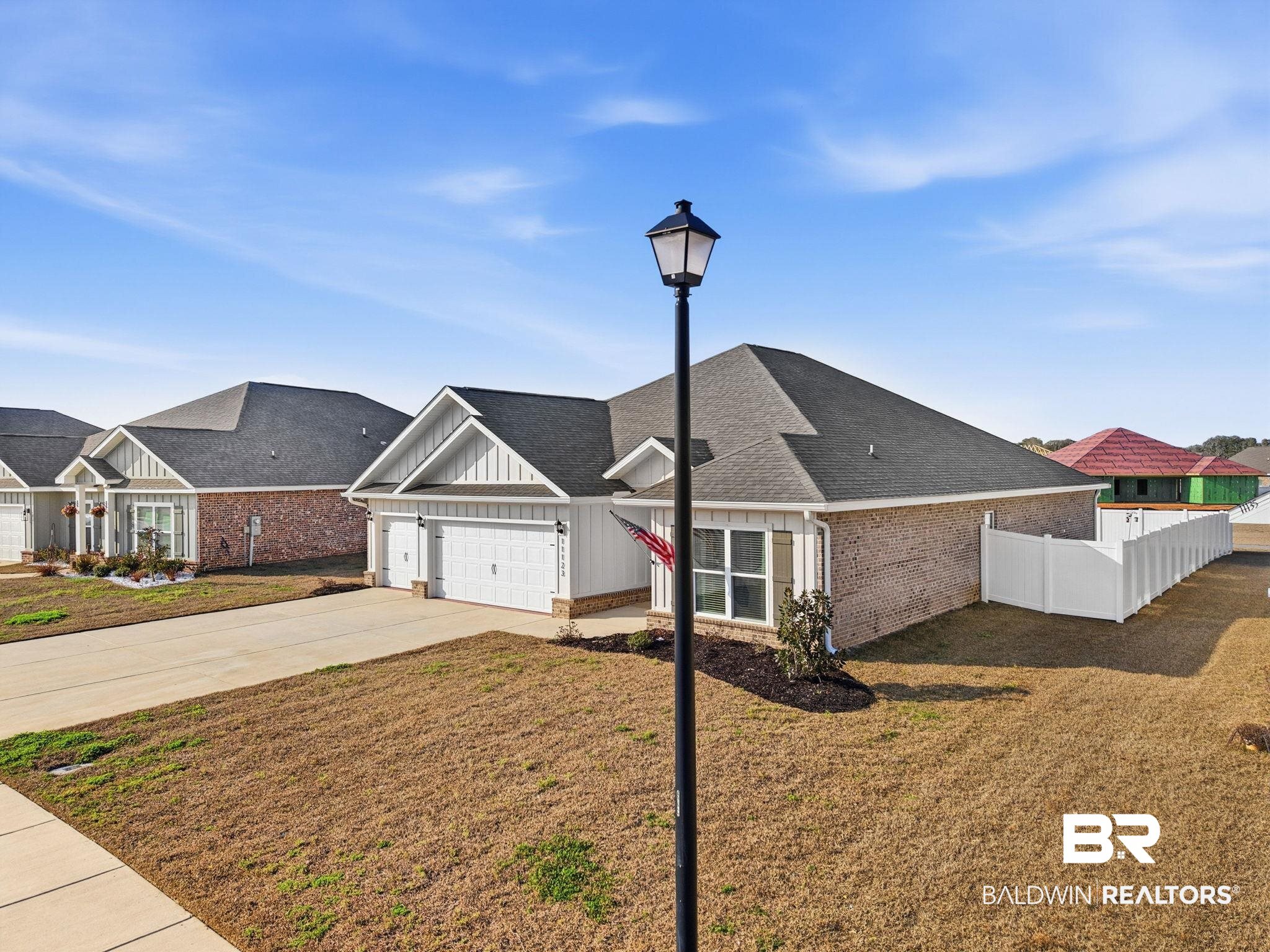 11123 Genuine Risk Circle Daphne, AL 36526 - Photo 1 of 67 View of front of house featuring board and batten siding, concrete driveway, a garage, brick siding, and roof with shingles
