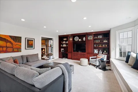 a bedroom with furniture a flat screen tv and a large window