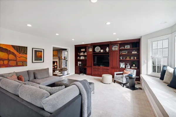 a bedroom with furniture a flat screen tv and a large window