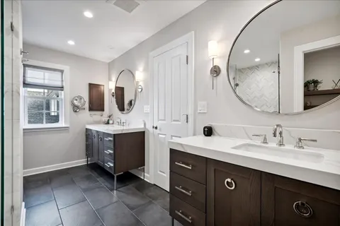 a bathroom with a double vanity sink mirror and bathtub