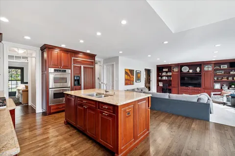 a large kitchen with stainless steel appliances granite countertop a large counter top and a wooden floors