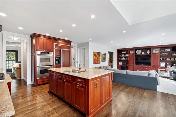 a large kitchen with stainless steel appliances granite countertop a large counter top and a wooden floors