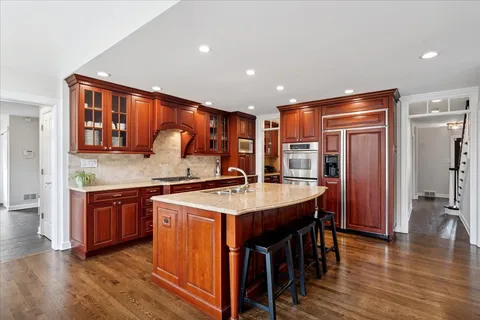a kitchen with stainless steel appliances granite countertop wooden floors and sink