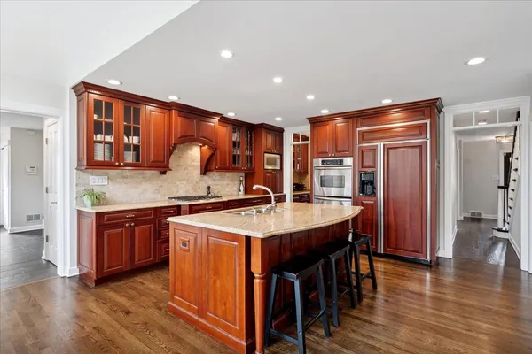 a kitchen with stainless steel appliances granite countertop wooden floors and sink