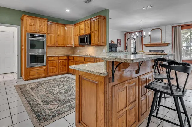 a kitchen with stainless steel appliances granite countertop a refrigerator a stove top oven and sink