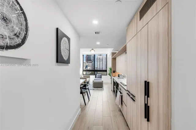 a kitchen with a refrigerator and a wooden floor