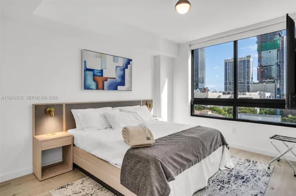 a bedroom with a bed and a large window