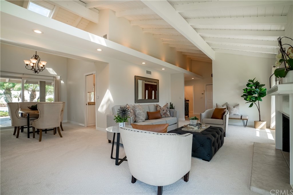 1001 Castlegate Lane North Tustin, CA 92705 - Photo 7 of 30 living room with fireplace and dining room overlooking backyard.