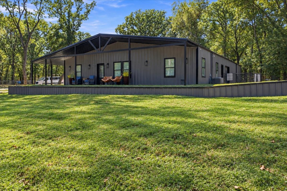 12 Hoot Loop Cartwright, OK 74731 - Photo 3 of 35 Grey corrugated metal exterior with black trim, a covered front porch, and a level lawn