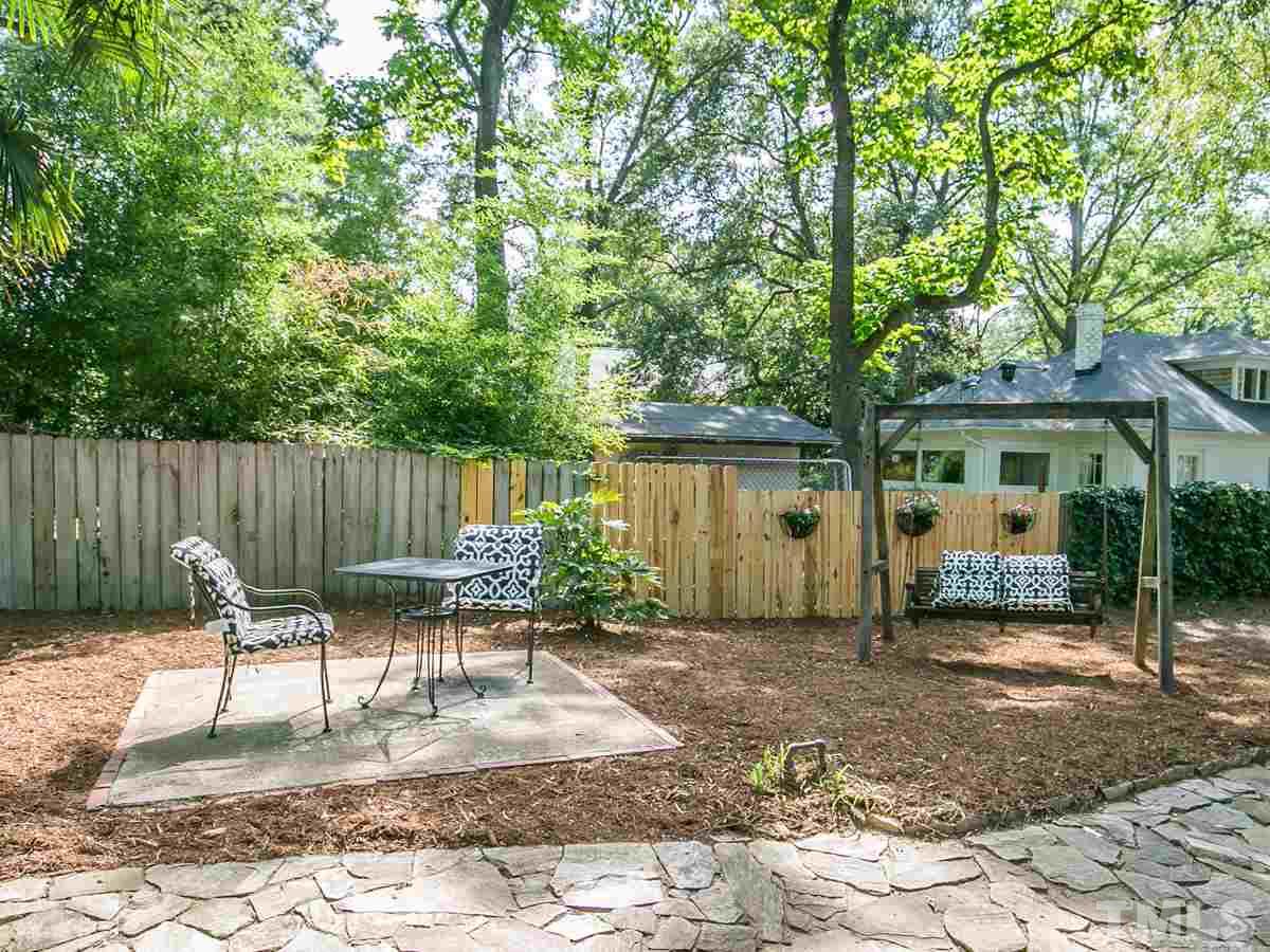 1614 Scales Street Raleigh, NC 27608 - Photo 22 of 25 a backyard of a house with lawn chairs and large tree