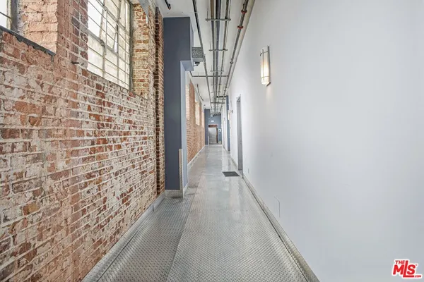 a view of a hallway with wooden floor and brick walls