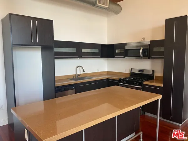 a kitchen with stainless steel appliances a sink and a refrigerator