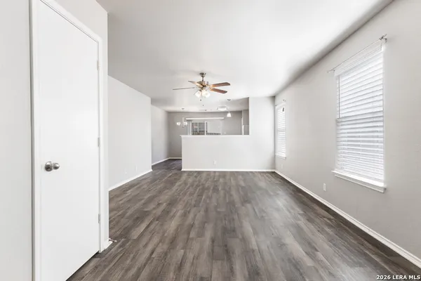 an empty room with wooden floor and windows
