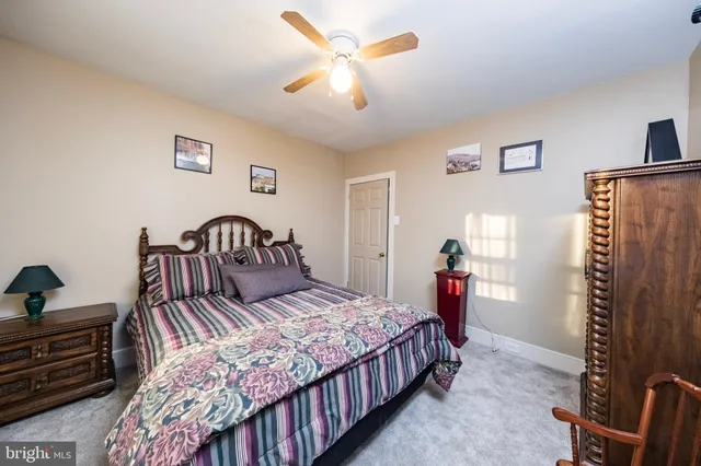 a bathroom with a granite countertop sink a toilet a mirror and shower
