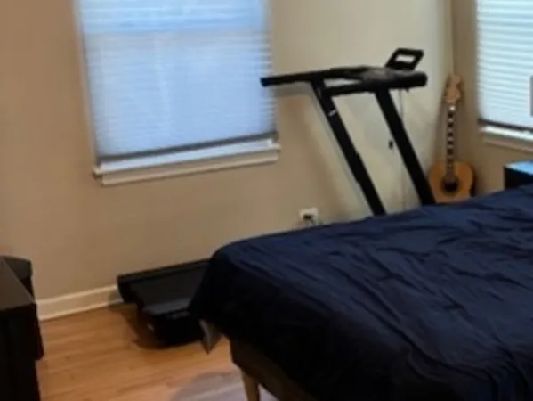 a bed sitting in a bedroom next to a window