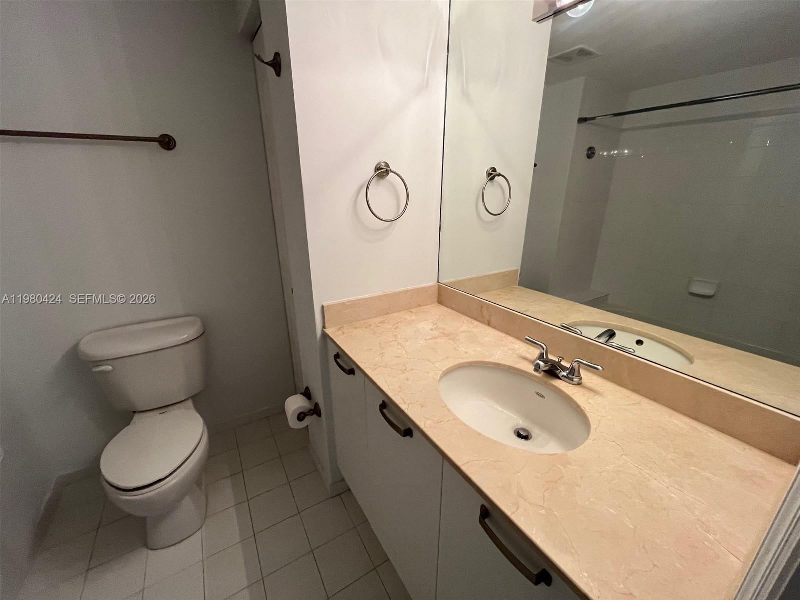 2030 Douglas Road, Unit 610 Coral Gables, FL 33134 - Photo 14 of 19 a bathroom with a granite countertop sink a mirror and a toilet