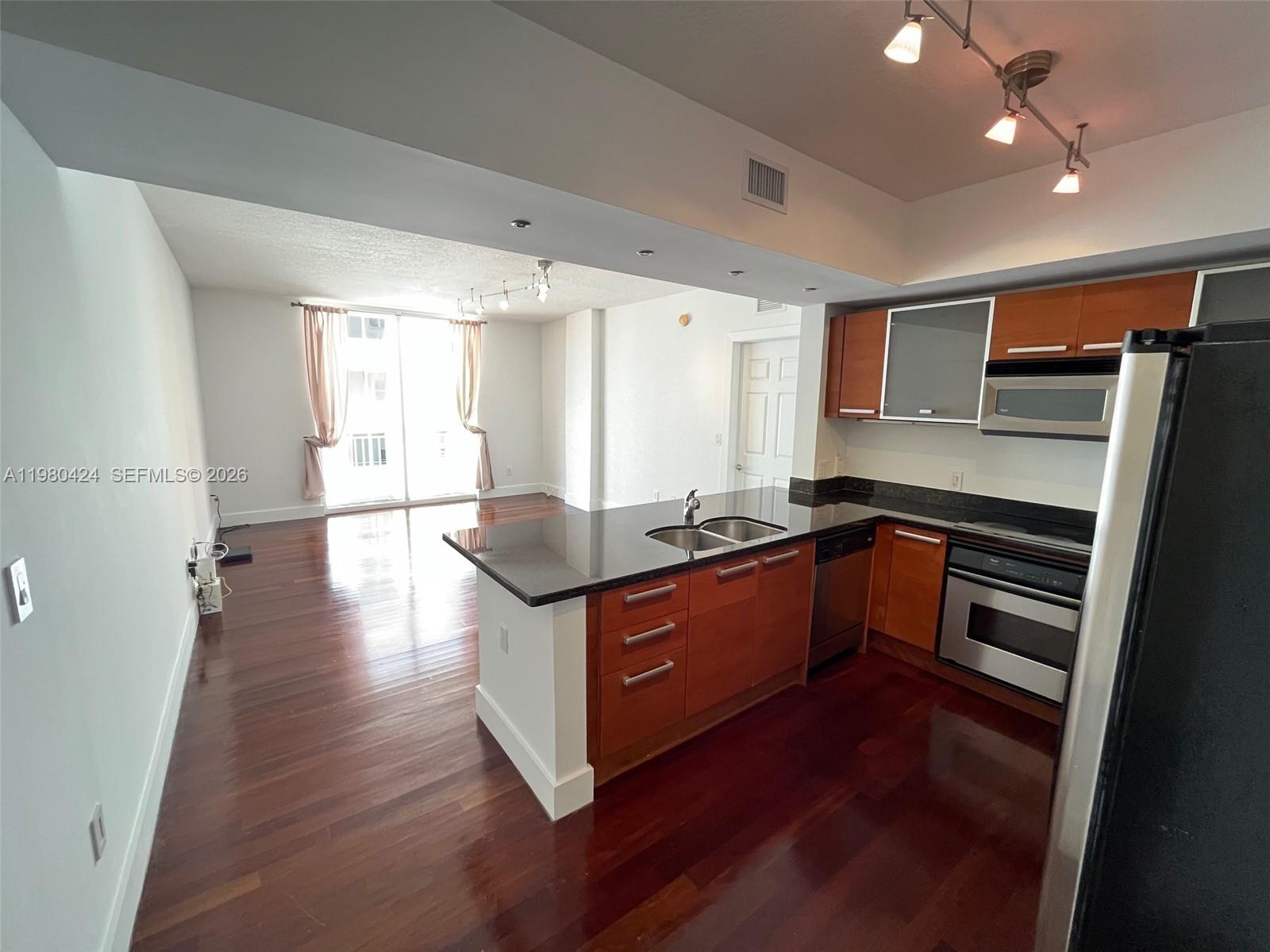 2030 Douglas Road, Unit 610 Coral Gables, FL 33134 - Photo 4 of 19 a kitchen with stainless steel appliances granite countertop a stove a sink and a refrigerator