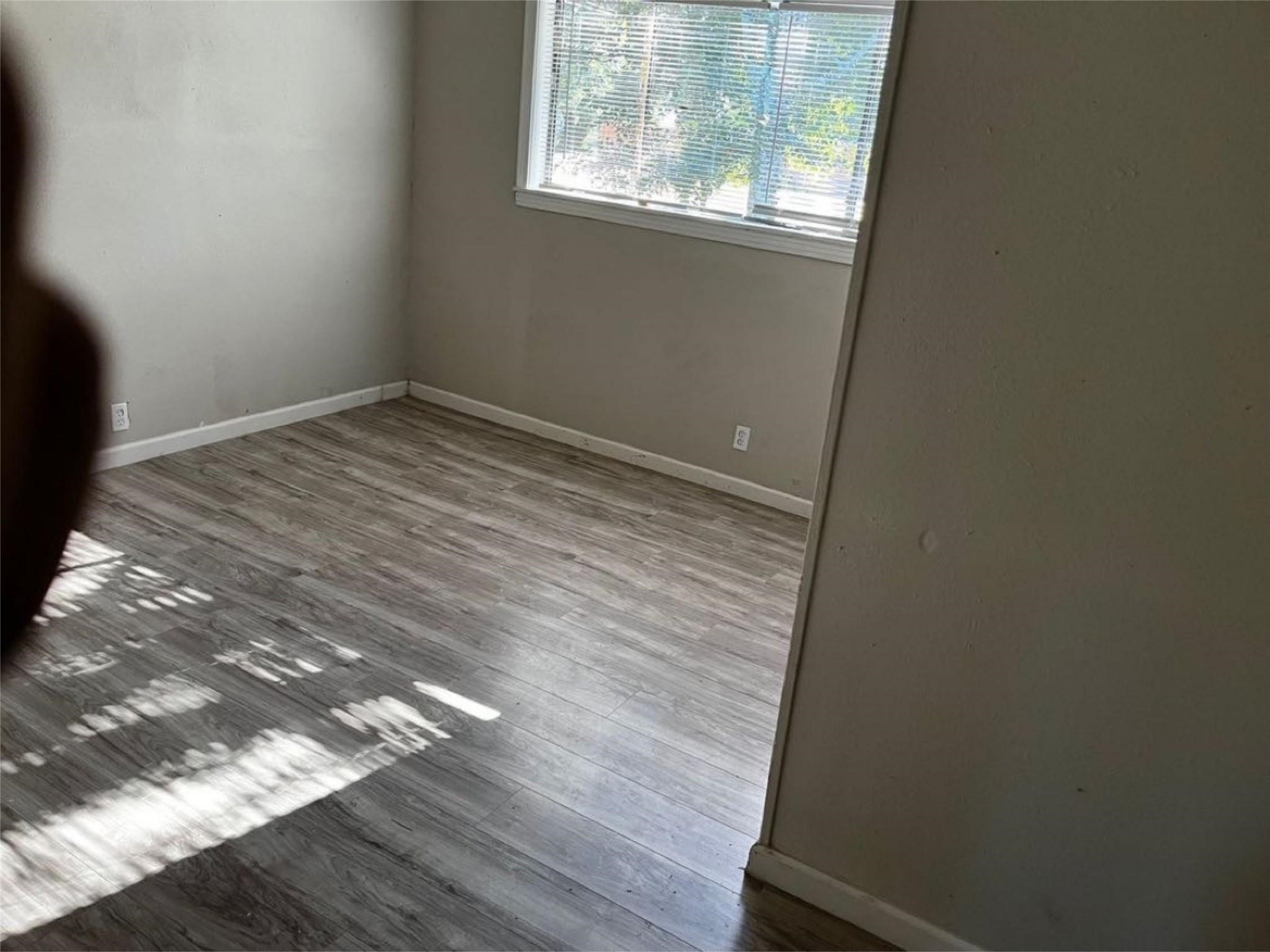 1648 West Rev Dr Ransom Howard Street Port Arthur, TX 77640 - Photo 4 of 12 a view of empty room with wooden floor and fan