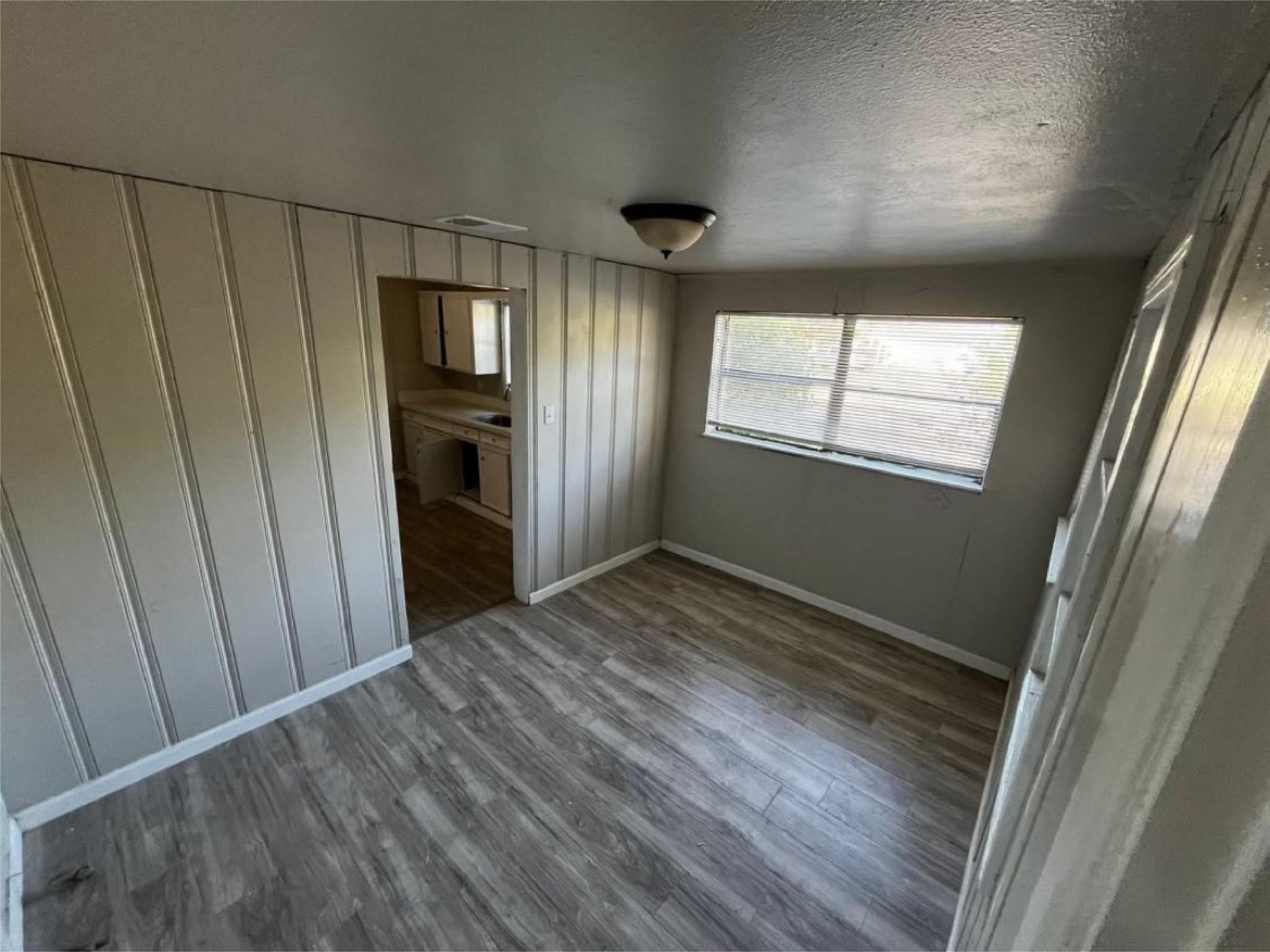 1648 West Rev Dr Ransom Howard Street Port Arthur, TX 77640 - Photo 5 of 12 a view of an empty room with wooden floor and a window