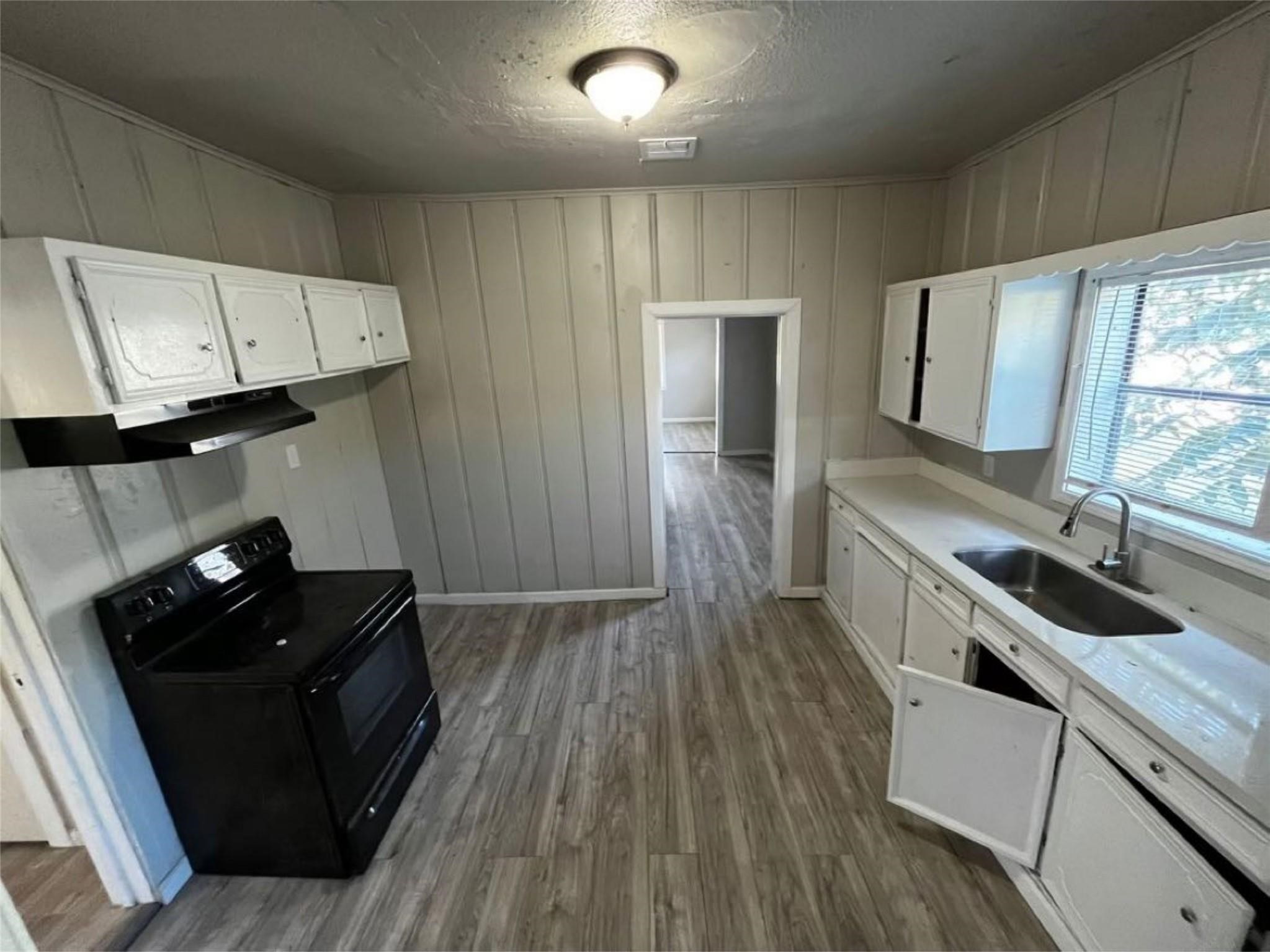 1648 West Rev Dr Ransom Howard Street Port Arthur, TX 77640 - Photo 7 of 12 a kitchen with a sink and wooden floor