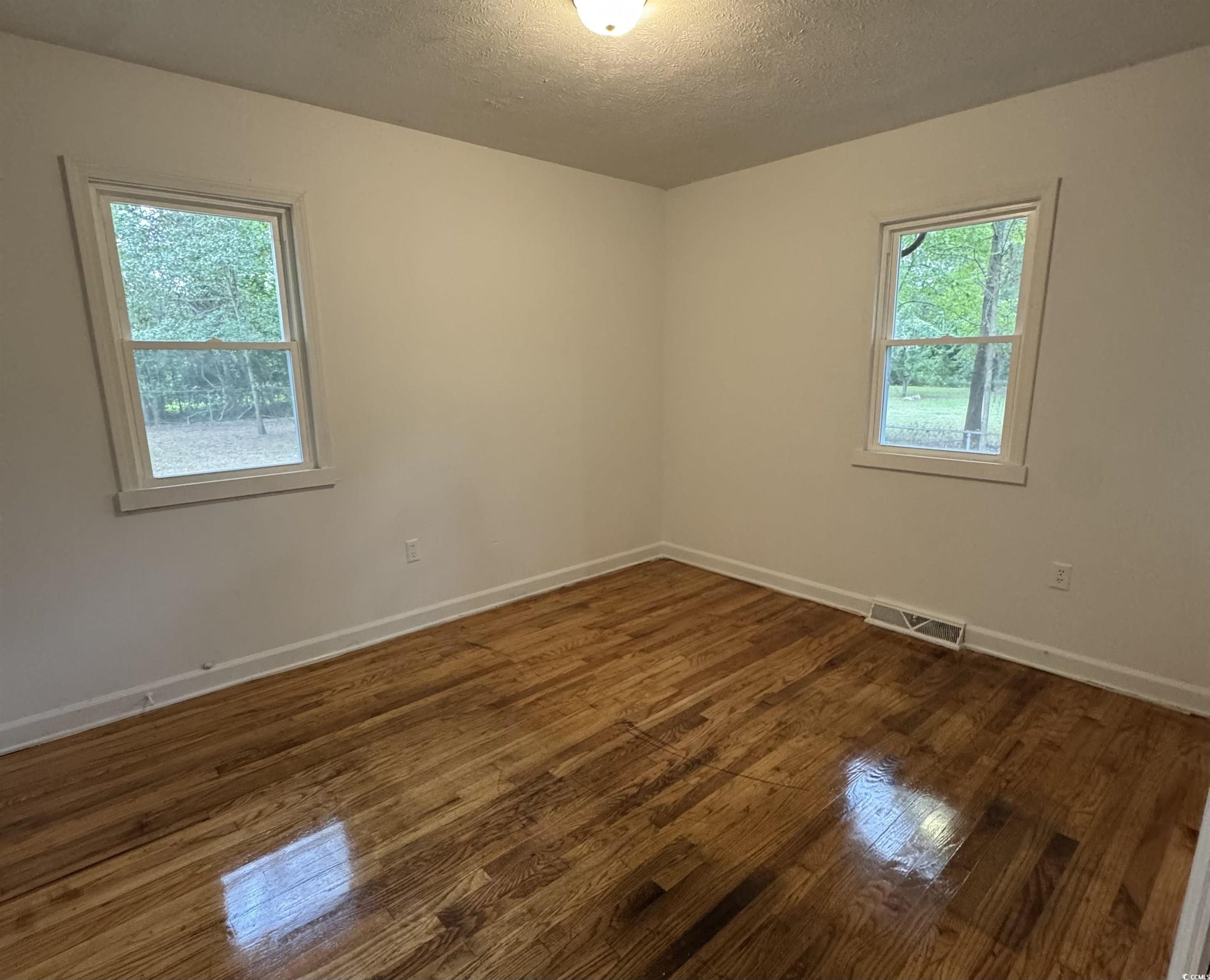 1127 State Rd S-17-640 Dillon, SC 29536 - Photo 22 of 26 Unfurnished room with a textured ceiling and dark wood-style floors