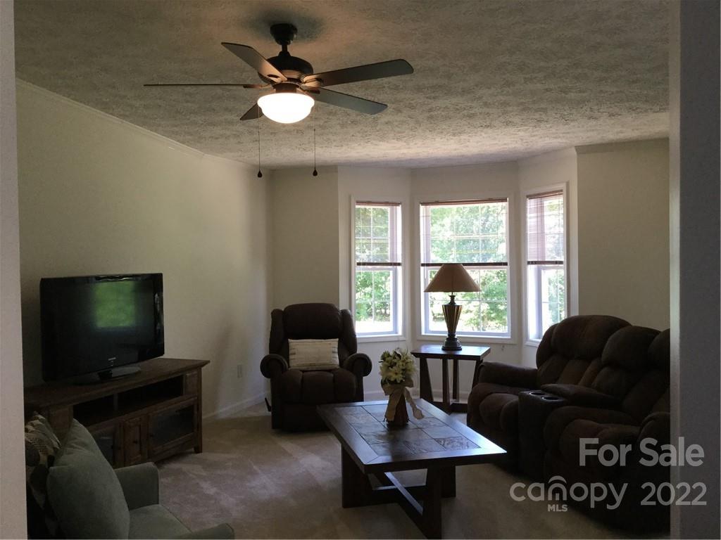 134 V S Dalton Road Rutherfordton, NC 28139 - Photo 16 of 43 a living room with furniture a chandelier and a flat screen tv