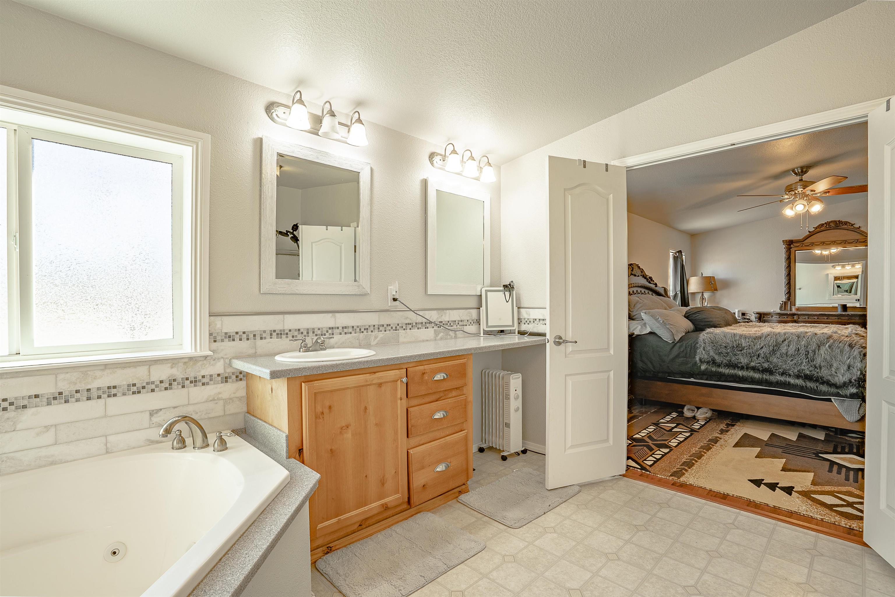 714-100 Sears Road Janesville, CA 96114 - Photo 31 of 35 a en suite bathroom with a double vanity sink large mirror and a bathtub
