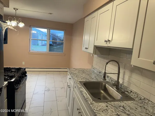 a kitchen with a sink a stove and cabinets