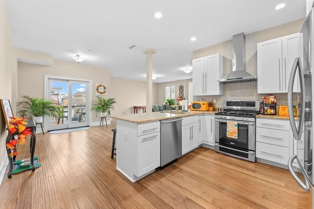 a kitchen with granite countertop a refrigerator and a stove top oven