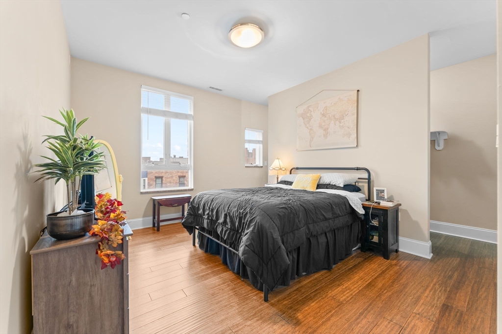 380 West Broadway, Unit 401 Boston, MA 02127 - Photo 13 of 25 a spacious bedroom with a bed and wooden floor