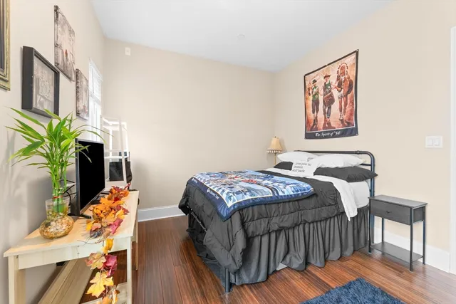a bedroom with bed and wooden floor