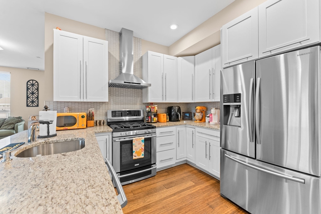 380 West Broadway, Unit 401 Boston, MA 02127 - Photo 2 of 25 a kitchen with stainless steel appliances granite countertop a refrigerator stove and sink