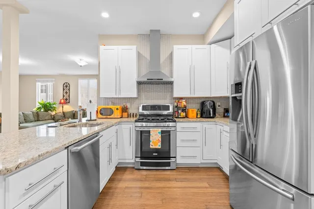a kitchen with stainless steel appliances granite countertop a stove and a refrigerator
