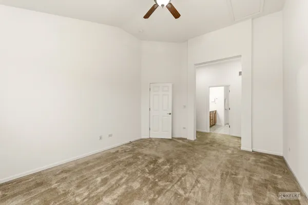 an empty room with ceiling fan and window
