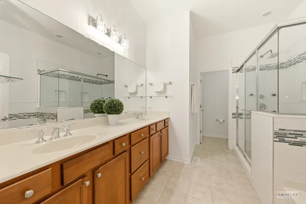 a spacious bathroom with a double vanity sink mirror and shower