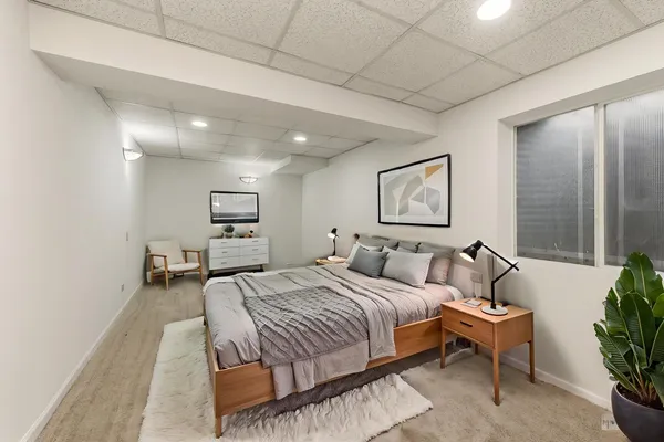 a bedroom with a large bed and a potted plant