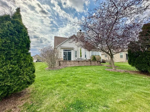 a front view of a house with yard and green space