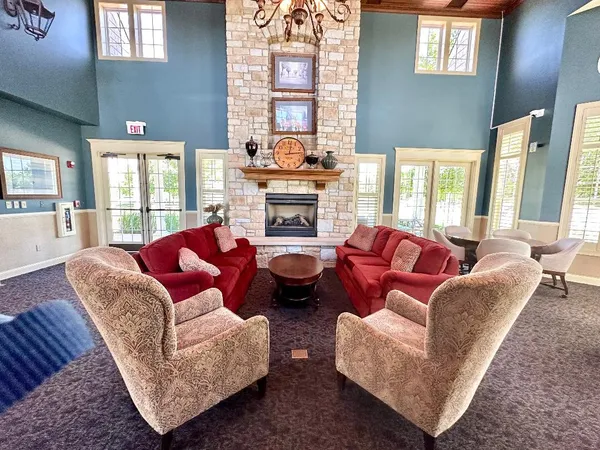 a living room with furniture fireplace and a large window